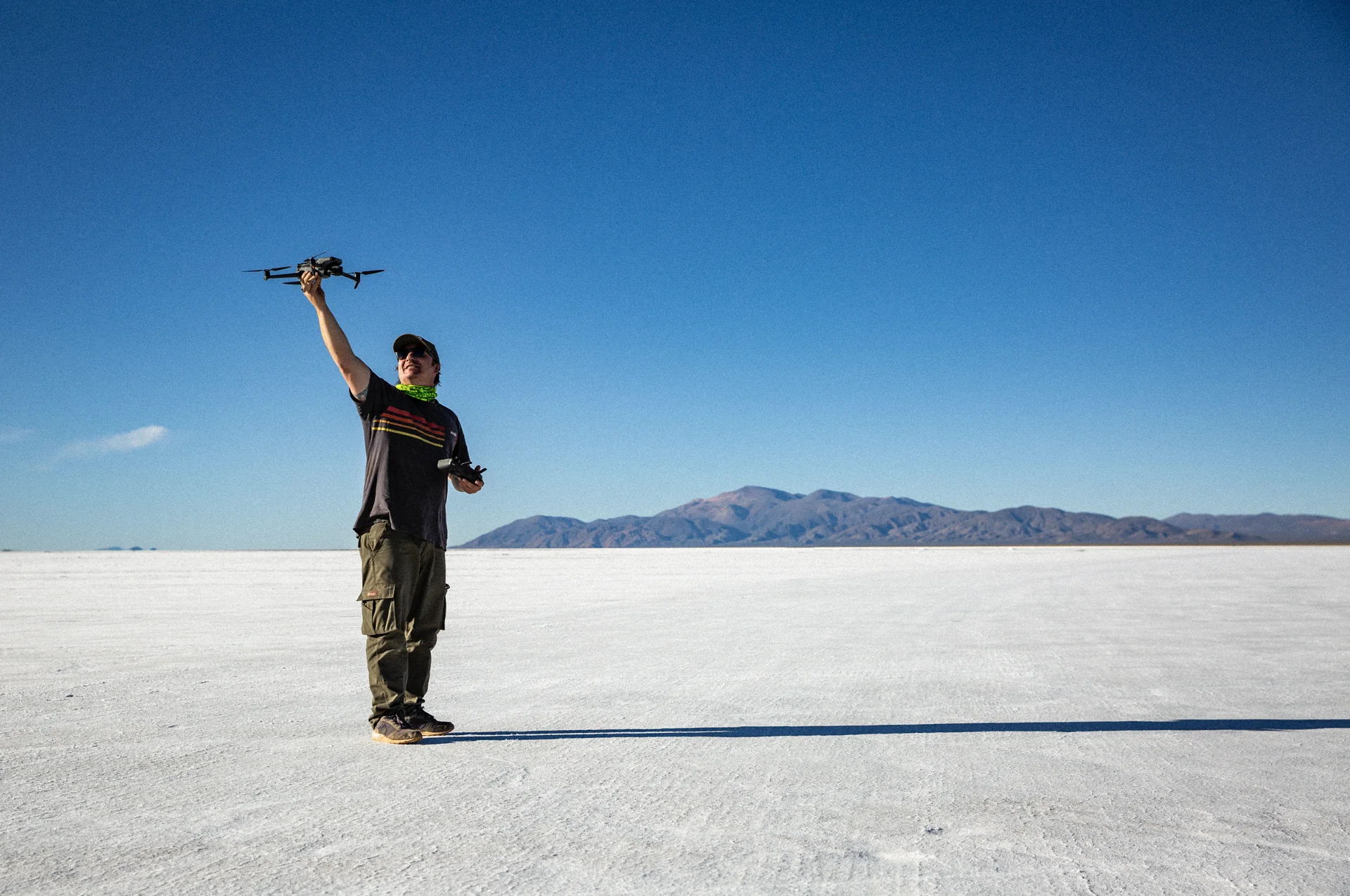 Operador de dron preparando un vuelo en un paisaje natural de gran extensión.